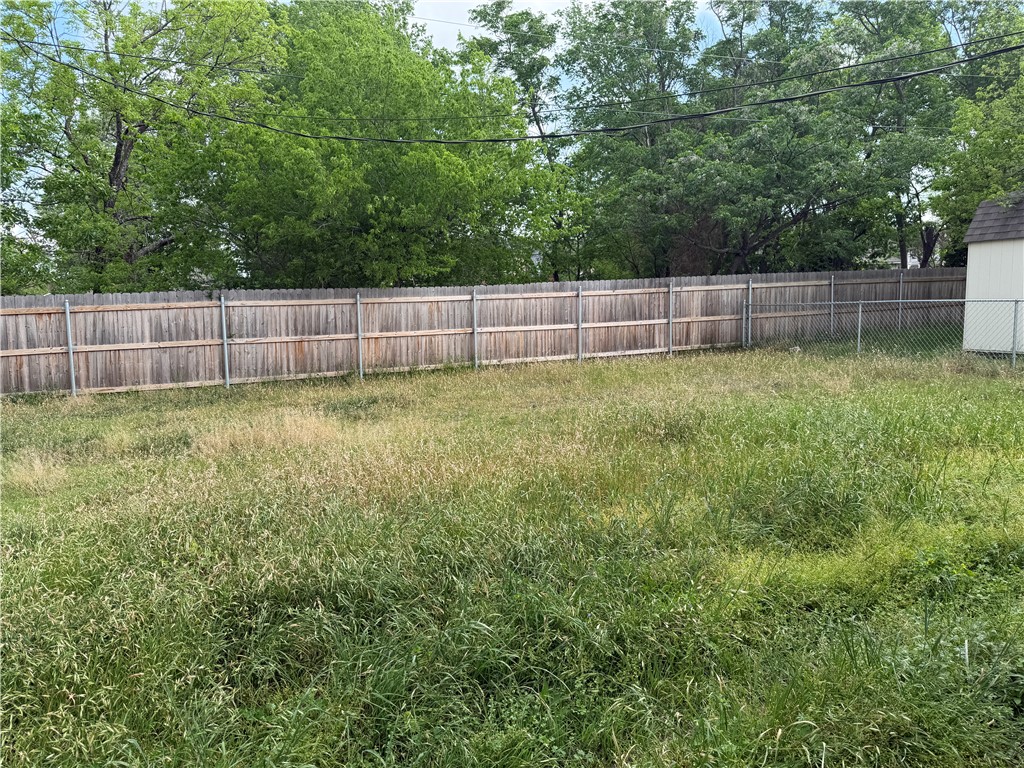 306 West 23rd Street Bryan, TX 77803 - Photo 12 of 12 a view of a backyard with a small cabin and a chair