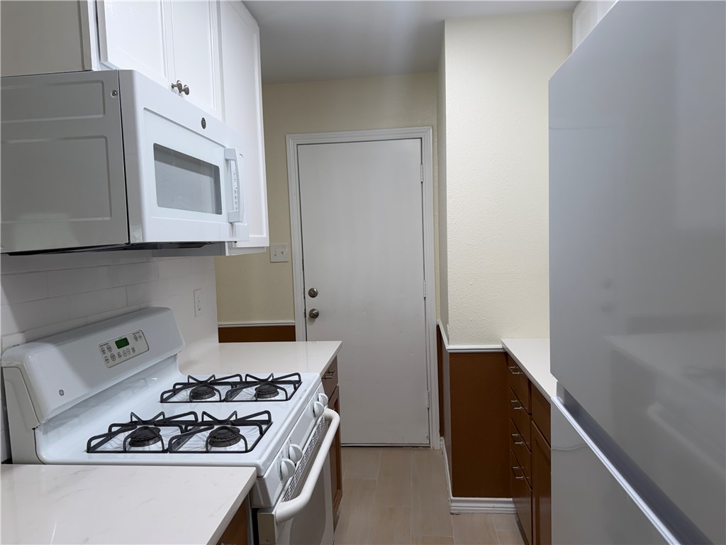306 West 23rd Street Bryan, TX 77803 - Photo 4 of 12 a kitchen with a stove and a microwave