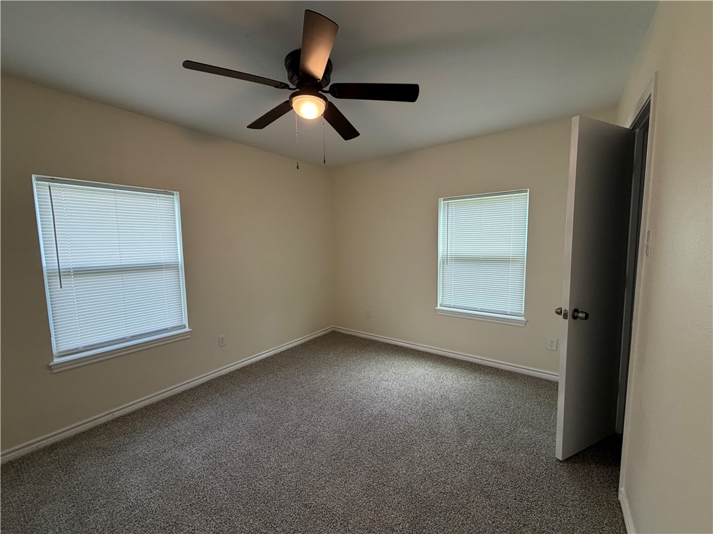 306 West 23rd Street Bryan, TX 77803 - Photo 6 of 12 an empty room with a chandelier fan and windows