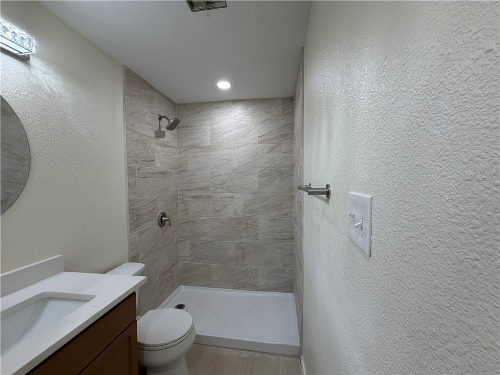 306 West 23rd Street Bryan, TX 77803 - Photo 8 of 12 a bathroom with a bathtub shower sink vanity and toilet