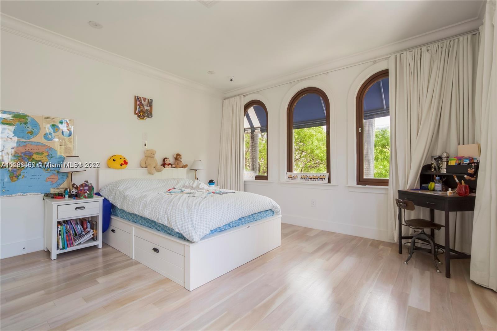 5768 Pine Tree Drive Miami Beach, FL 33140 - Photo 15 of 17 a living room with baby furniture and a window