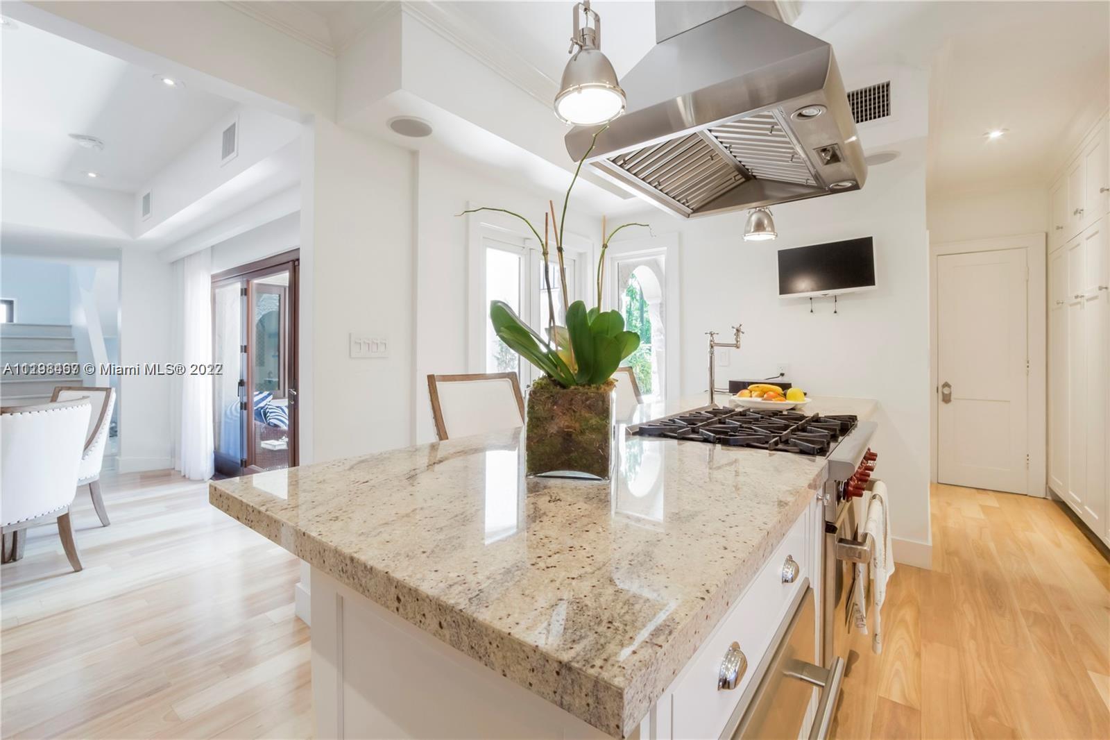 5768 Pine Tree Drive Miami Beach, FL 33140 - Photo 7 of 17 a kitchen with stainless steel appliances granite countertop a sink and a wooden floor