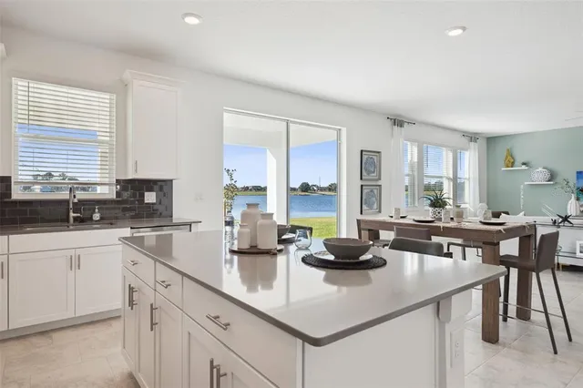 a kitchen with sink a stove and white cabinets with wooden floor