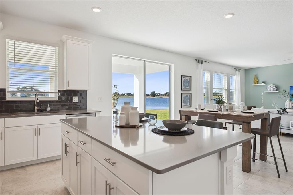 3012 Ella Way St. Cloud, FL 34771 - Photo 12 of 56 a kitchen with sink a stove and white cabinets with wooden floor
