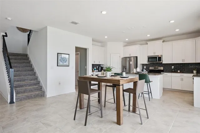 a kitchen with stainless steel appliances kitchen island granite countertop a refrigerator and cabinets