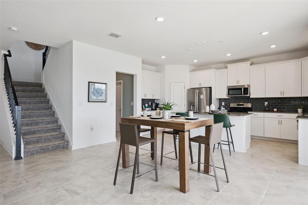 3012 Ella Way St. Cloud, FL 34771 - Photo 10 of 56 a kitchen with stainless steel appliances kitchen island granite countertop a refrigerator and cabinets