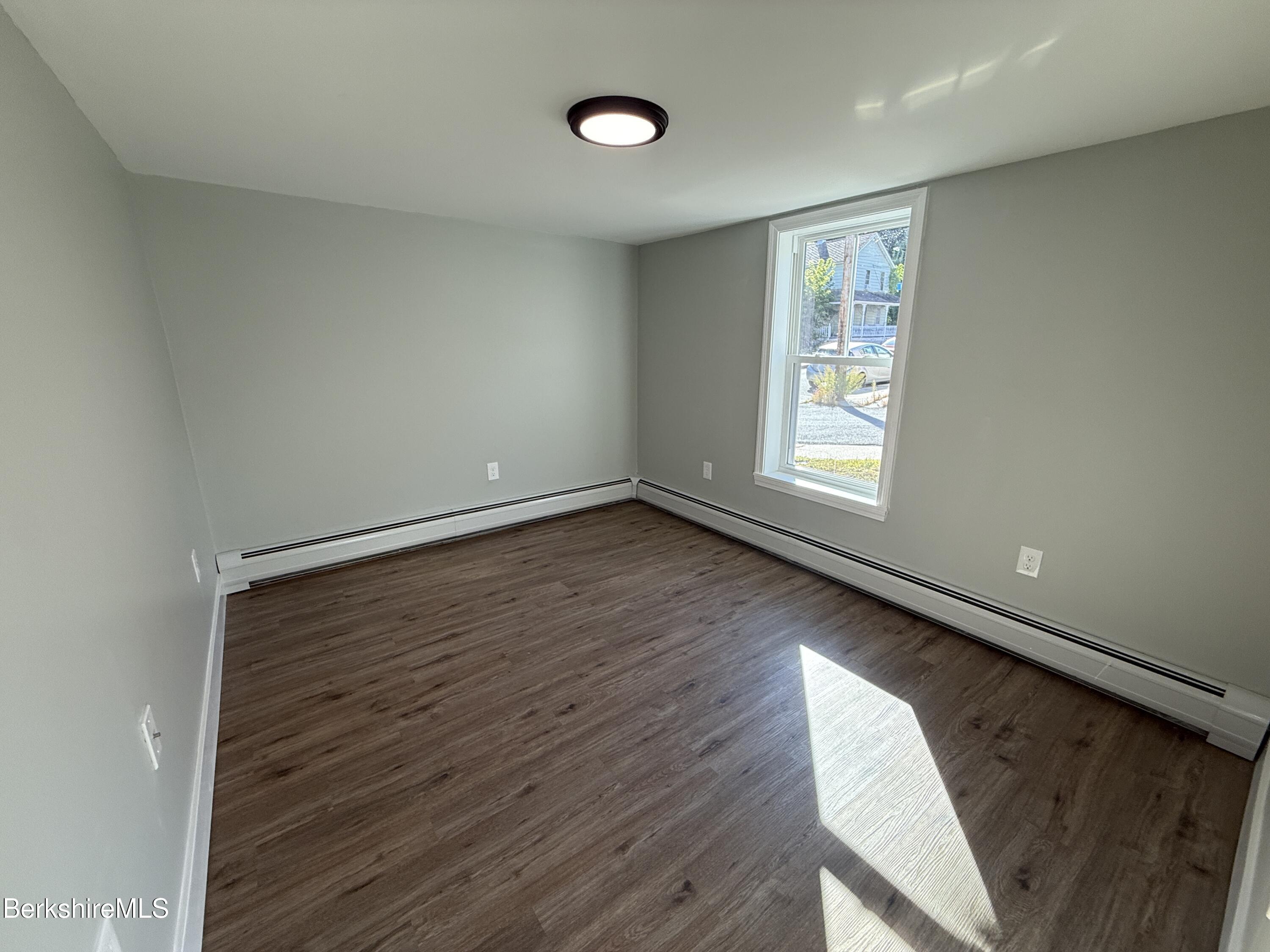 17 Elm Street, Unit A Adams, MA 01220 - Photo 13 of 17 an empty room with wooden floor and windows