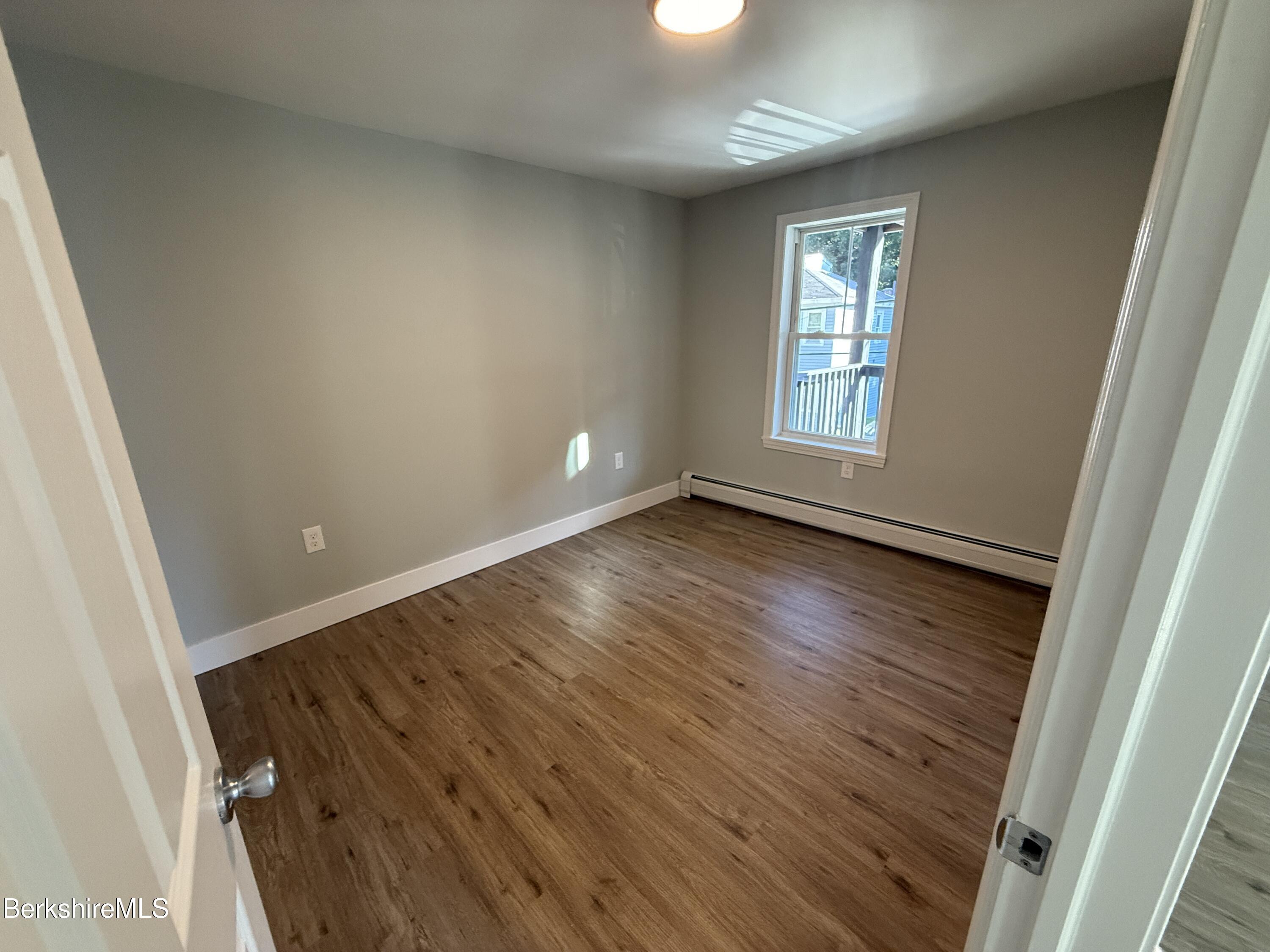 17 Elm Street, Unit A Adams, MA 01220 - Photo 3 of 17 an empty room with wooden floor and windows