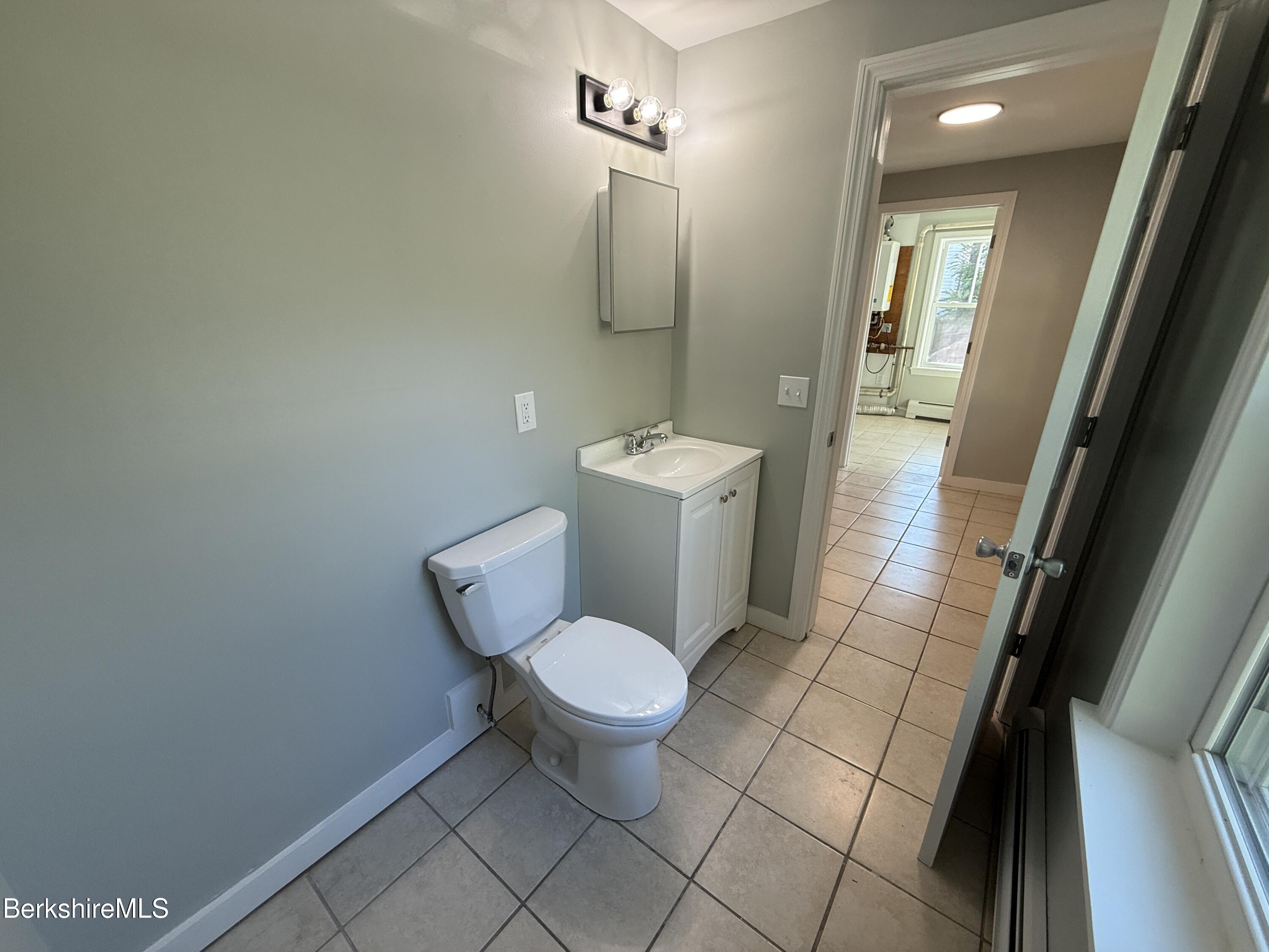 17 Elm Street, Unit A Adams, MA 01220 - Photo 6 of 17 a white toilet sitting next to a bathroom sink and a mirror