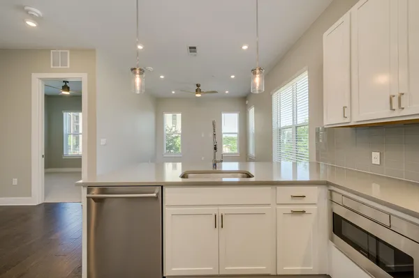 a kitchen with stainless steel appliances granite countertop white cabinets and window