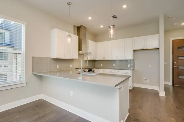 a kitchen with stainless steel appliances granite countertop white cabinets a sink and dishwasher