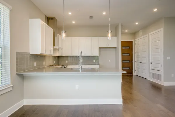 a kitchen with kitchen island a sink stainless steel appliances and cabinets