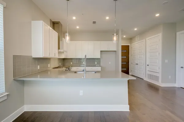 a large kitchen with stainless steel appliances granite countertop a lot of counter space and a refrigerator