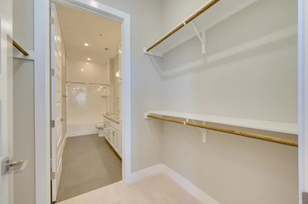 a view of kitchen with kitchen island a sink wooden floor and stainless steel appliances