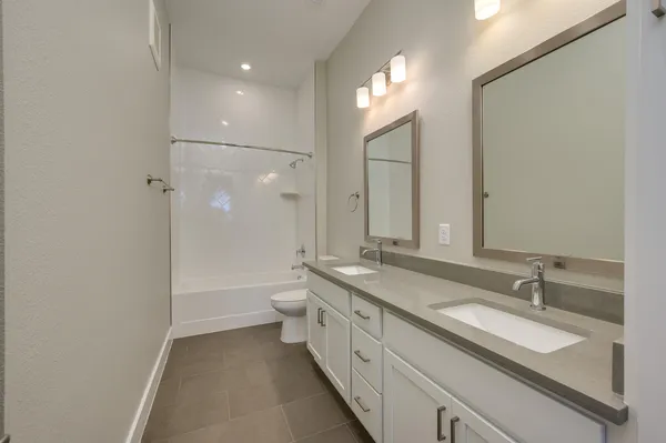 a large kitchen with stainless steel appliances granite countertop a sink a stove and a refrigerator