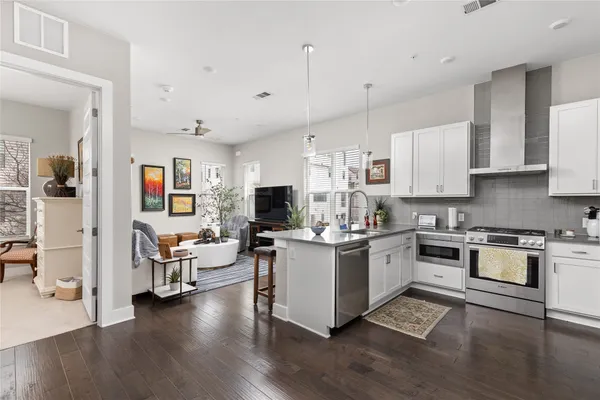 a view of a patio with table and chairs potted plants and a large tree