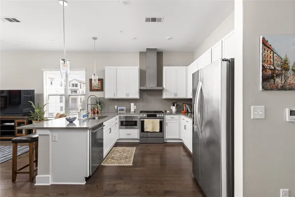 a kitchen with stainless steel appliances and view of living room