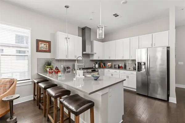 a kitchen with stainless steel appliances granite countertop a stove a sink and white cabinets