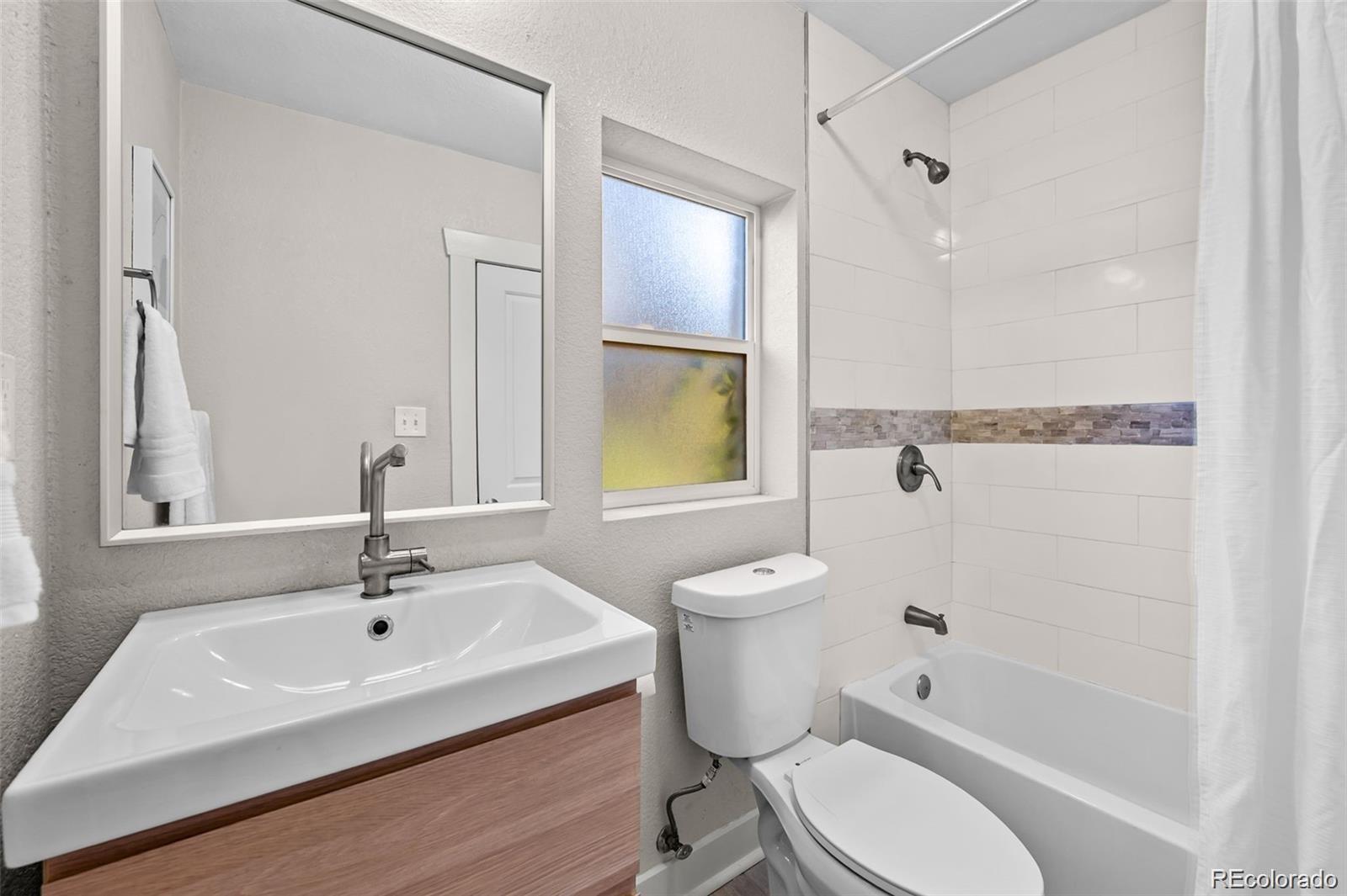 3649 Garfield Street Denver, CO 80205 - Photo 14 of 30 a white toilet sitting next to a bathroom sink