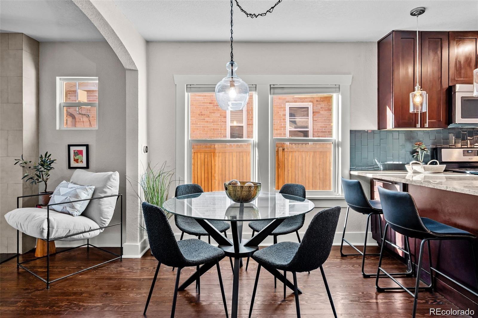 3649 Garfield Street Denver, CO 80205 - Photo 8 of 30 a dining room with furniture a chandelier and wooden floor