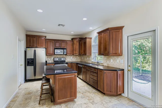 a kitchen with stainless steel appliances granite countertop a refrigerator stove and oven