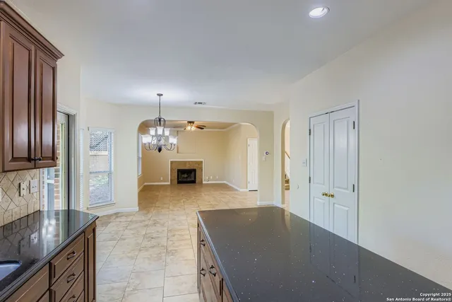 a kitchen with granite countertop a refrigerator and a stove top oven
