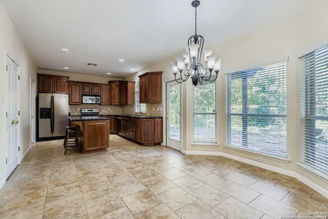 a kitchen with stainless steel appliances granite countertop a refrigerator and a stove top oven
