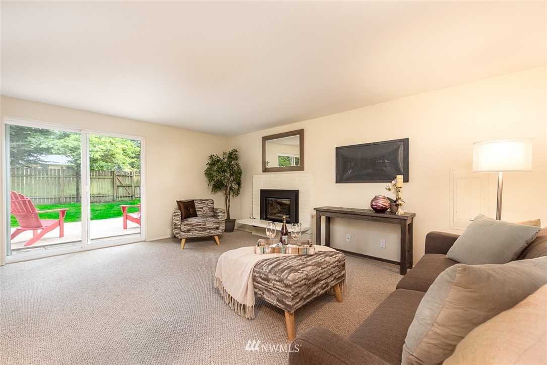 10044 Slater Avenue Northeast Kirkland, WA 98033 - Photo 11 of 21 a living room with furniture flat screen tv and a fireplace