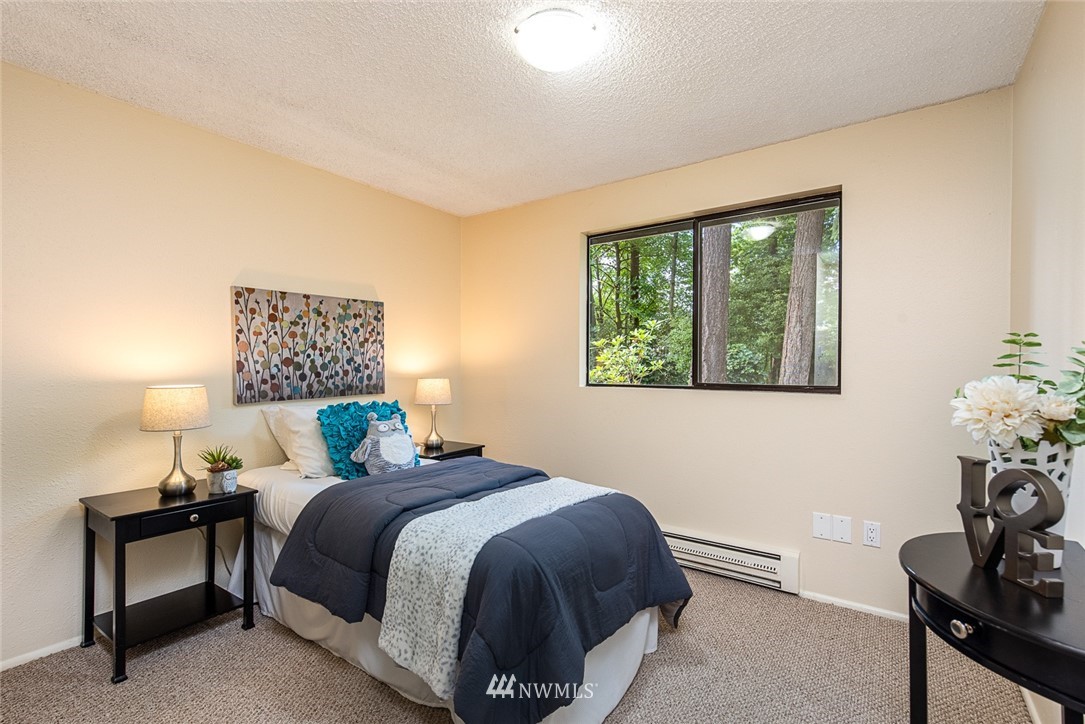 10044 Slater Avenue Northeast Kirkland, WA 98033 - Photo 14 of 21 a bedroom with a bed and a lamp next to a window