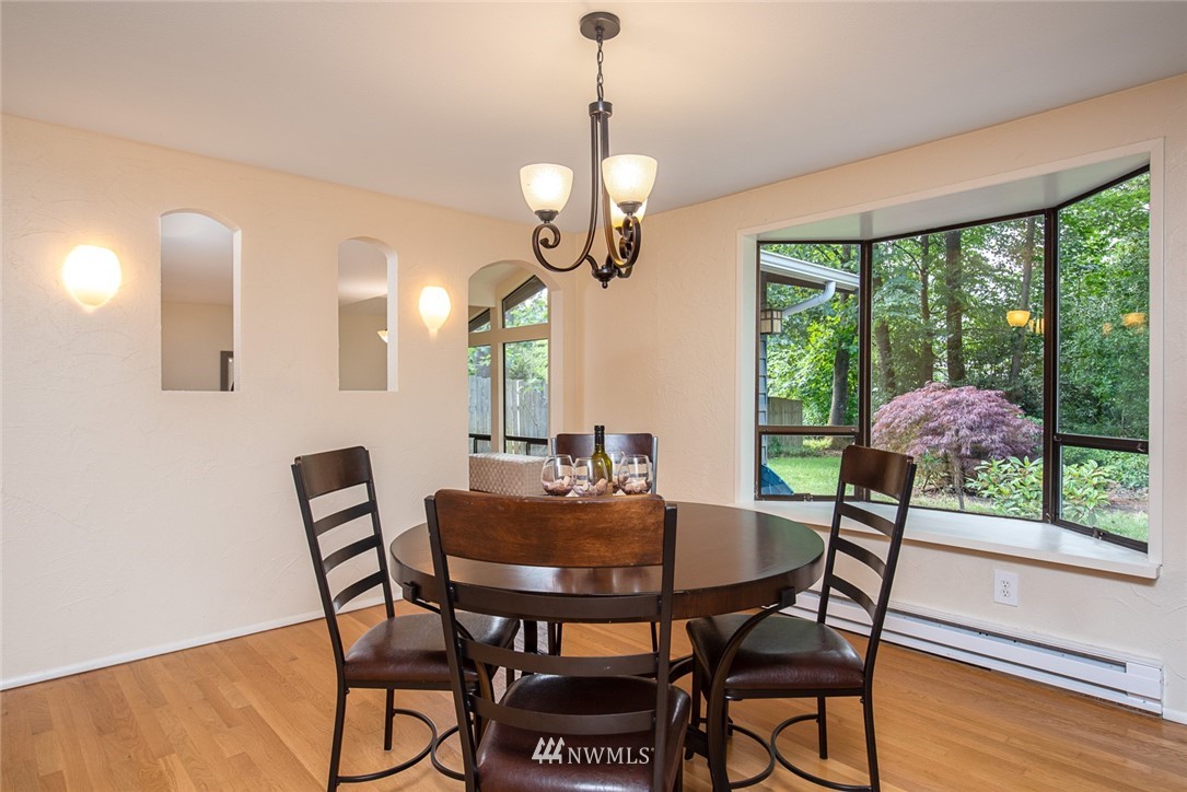 10044 Slater Avenue Northeast Kirkland, WA 98033 - Photo 5 of 21 a dining room with furniture a chandelier and wooden floor