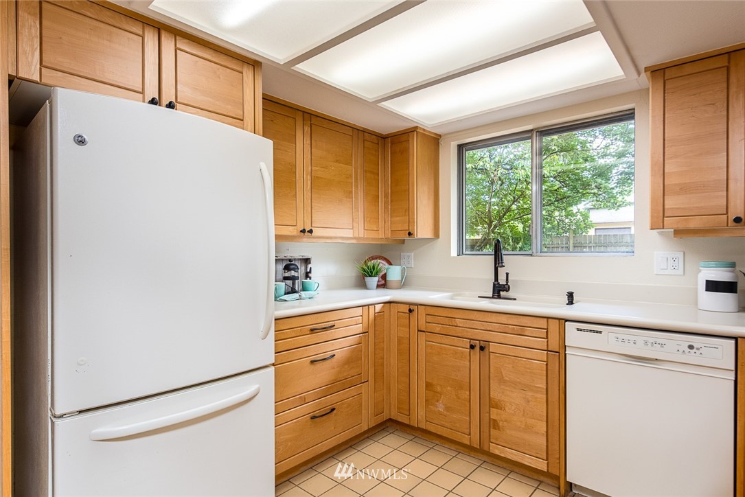 10044 Slater Avenue Northeast Kirkland, WA 98033 - Photo 7 of 21 a kitchen with a sink window and cabinets