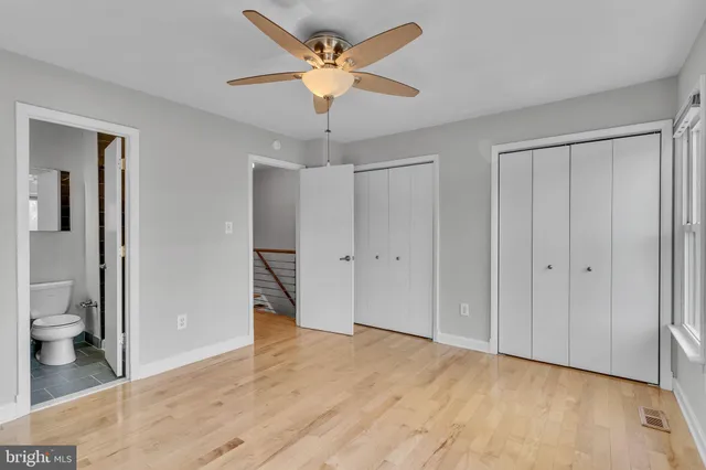 a big room with wooden floor and a bathroom view
