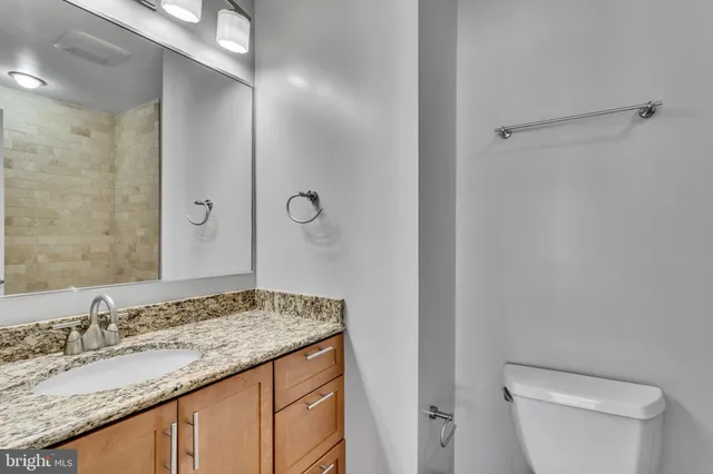 a bathroom with a granite countertop sink and a mirror