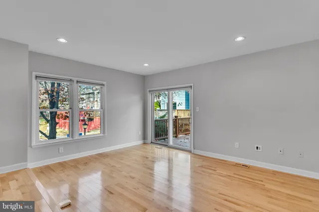 a view of an empty room with window and wooden floor