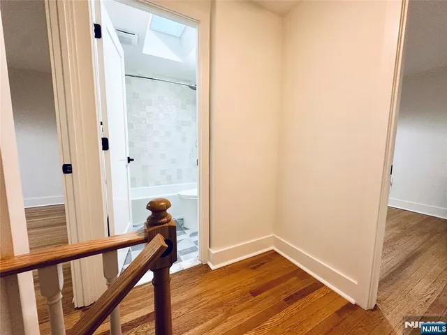 a view of a hallway with wooden floor and stairs