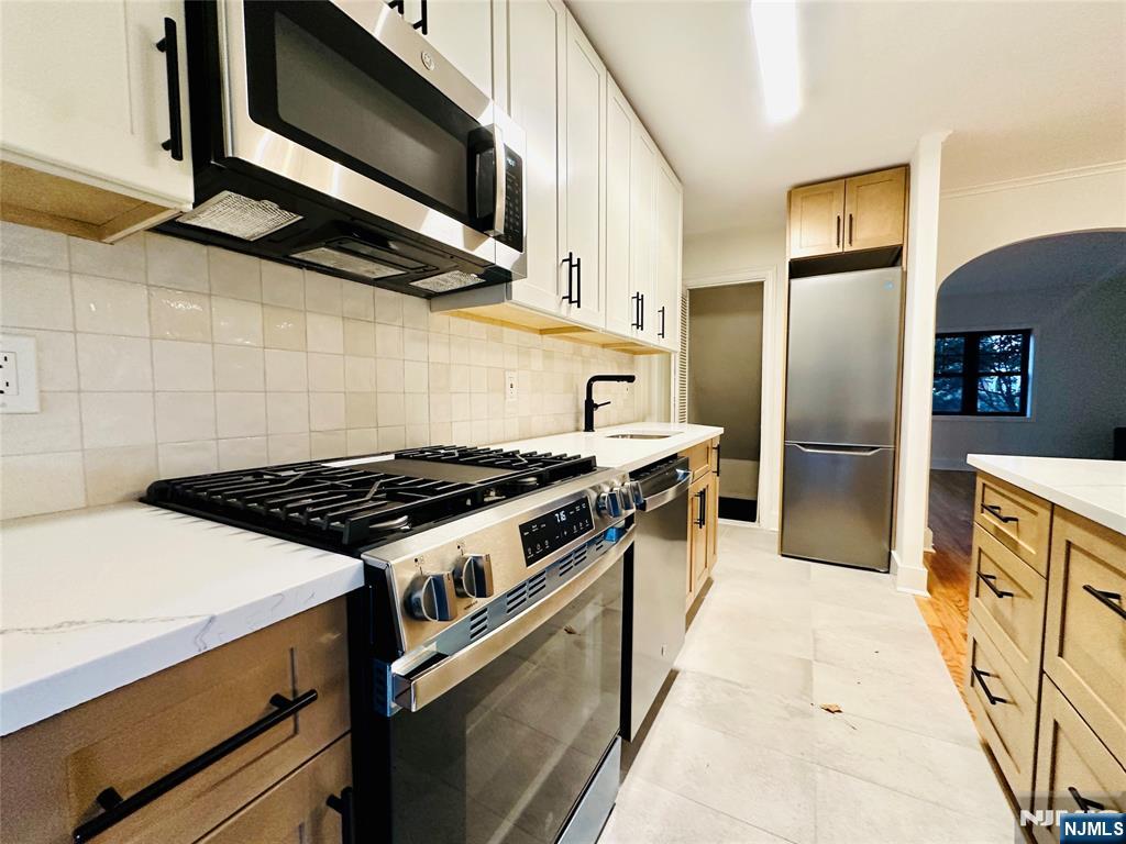 355 Valley Boulevard Wood-Ridge, NJ 07075 - Photo 8 of 24 a kitchen with stainless steel appliances granite countertop a stove a refrigerator and a microwave