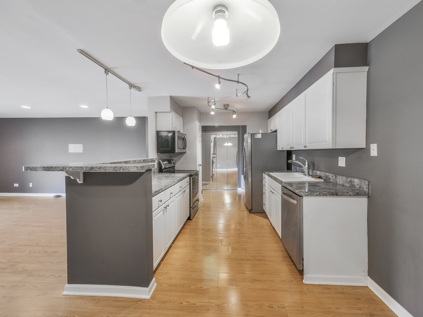 1747 West Crystal Lane, Unit 210 Mount Prospect, IL 60056 - Photo 15 of 33 a large kitchen with stainless steel appliances kitchen island granite countertop a large counter top a stove a chimney a sink and a refrigerator