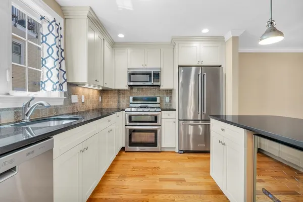 a kitchen with stainless steel appliances granite countertop a refrigerator sink and stove