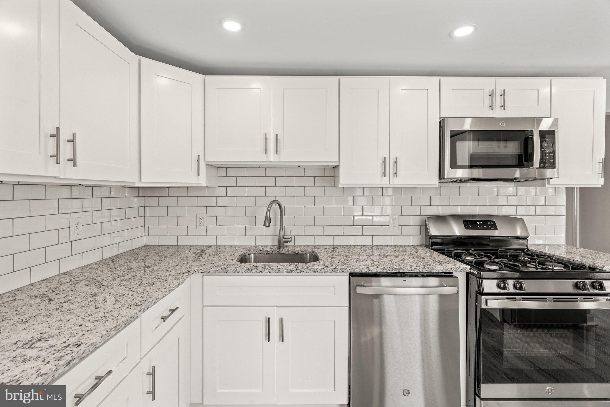 29 East 4th Street Burlington, NJ 08016 - Photo 11 of 27 a kitchen with granite countertop white cabinets sink and stainless steel appliances