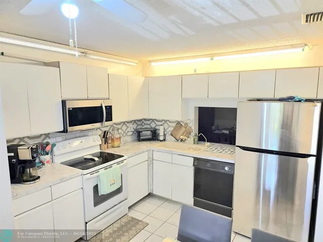 a kitchen with a refrigerator and a sink