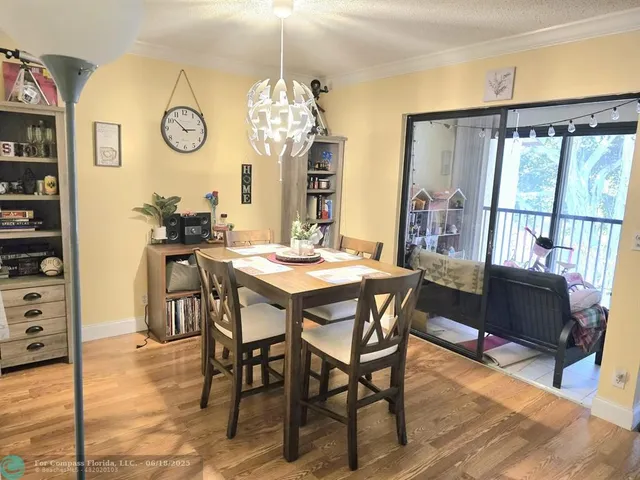 a view of a dining room and livingroom with furniture wooden floor and a clock