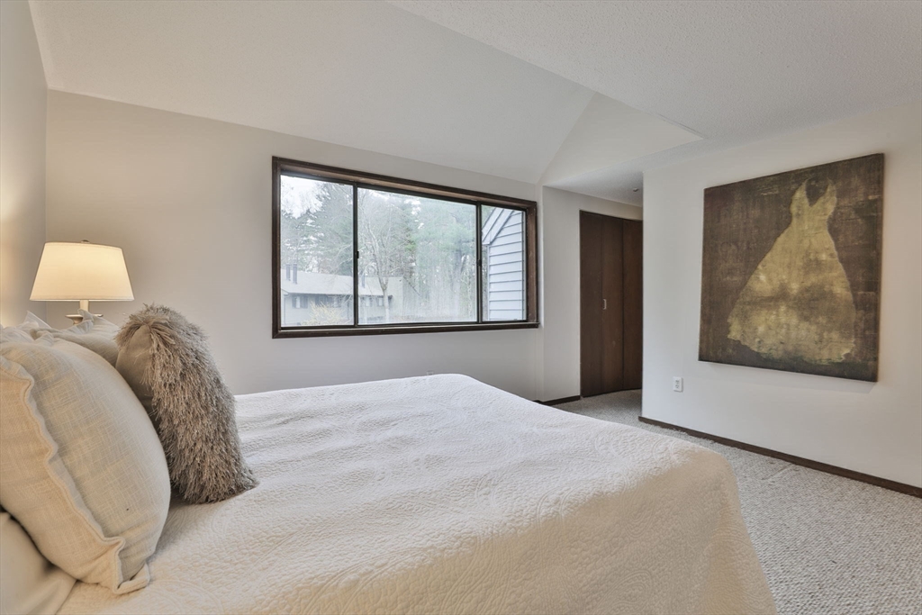 405 Great Elm Way, Unit 405 Acton, MA 01718 - Photo 15 of 19 a view of a bedroom with a large bed and a large window