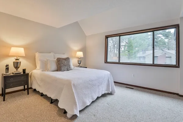 a bedroom with a bed lamp and window
