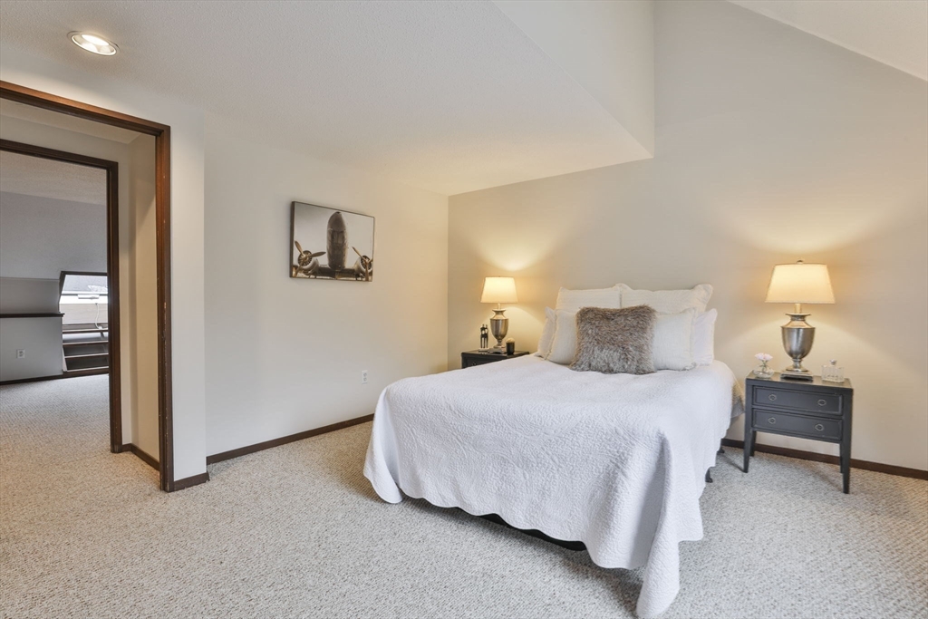405 Great Elm Way, Unit 405 Acton, MA 01718 - Photo 17 of 19 a bedroom with a bed and a lamp