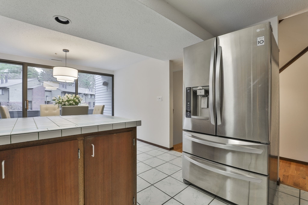 405 Great Elm Way, Unit 405 Acton, MA 01718 - Photo 6 of 19 a kitchen with stainless steel appliances a refrigerator and cabinets