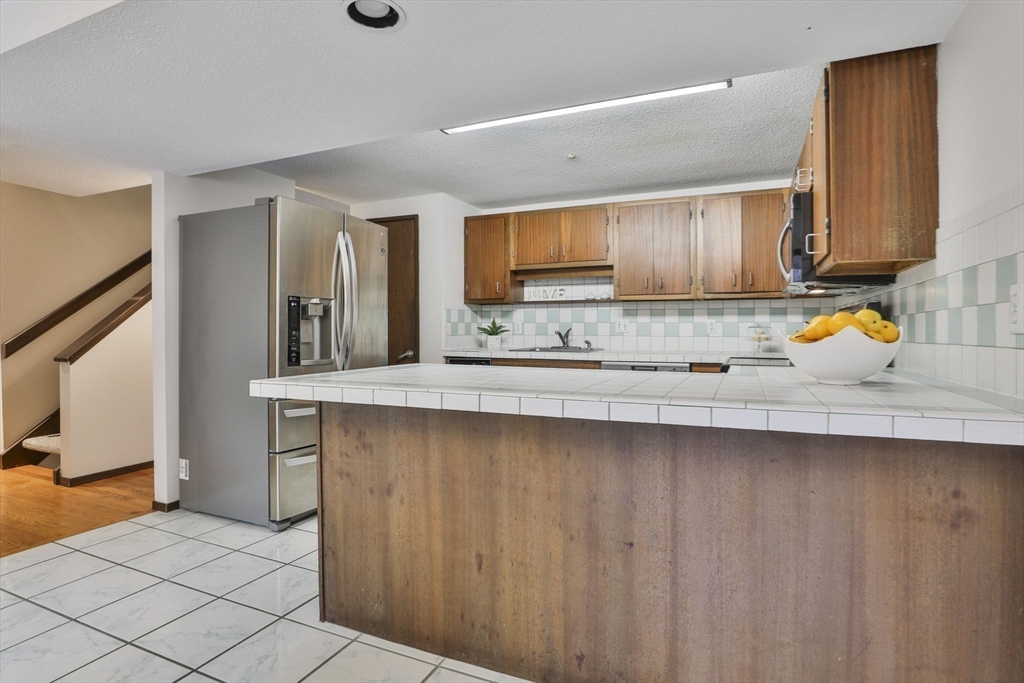 405 Great Elm Way, Unit 405 Acton, MA 01718 - Photo 7 of 19 a kitchen with stainless steel appliances a sink stove and cabinets