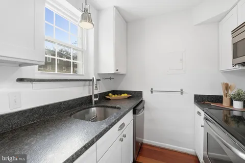 a kitchen with stainless steel appliances granite countertop a sink stove and cabinets
