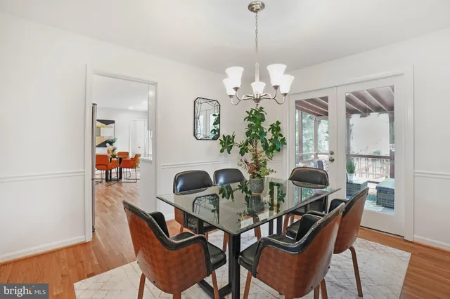 a view of a dining room with furniture a chandelier and wooden floor
