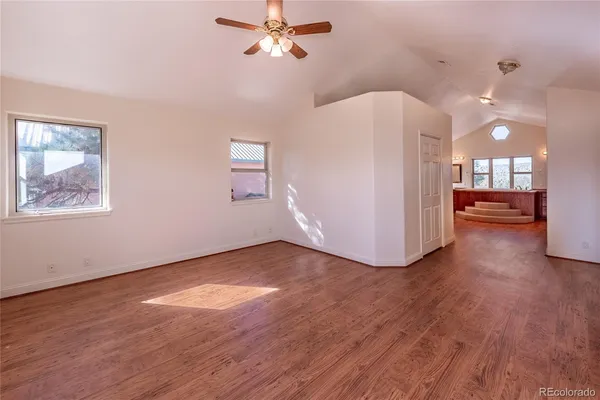 a view of a livingroom with wooden floor and a ceiling fan