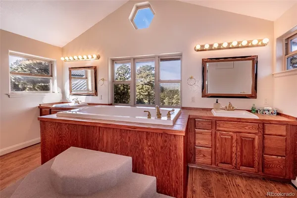 a spacious bathroom with a tub a sink and mirror